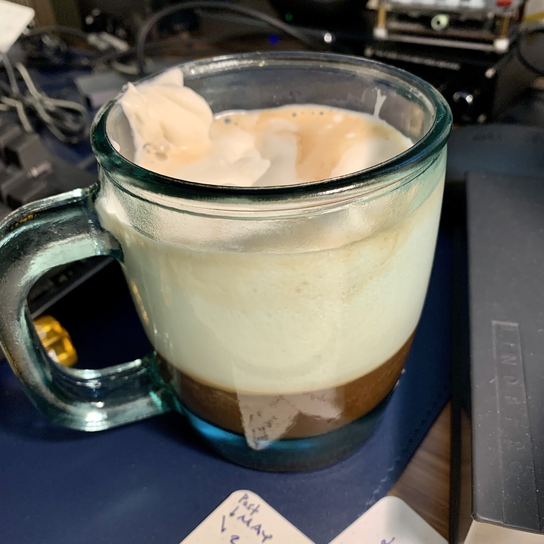 A mug of coffee with whipped cream on top.